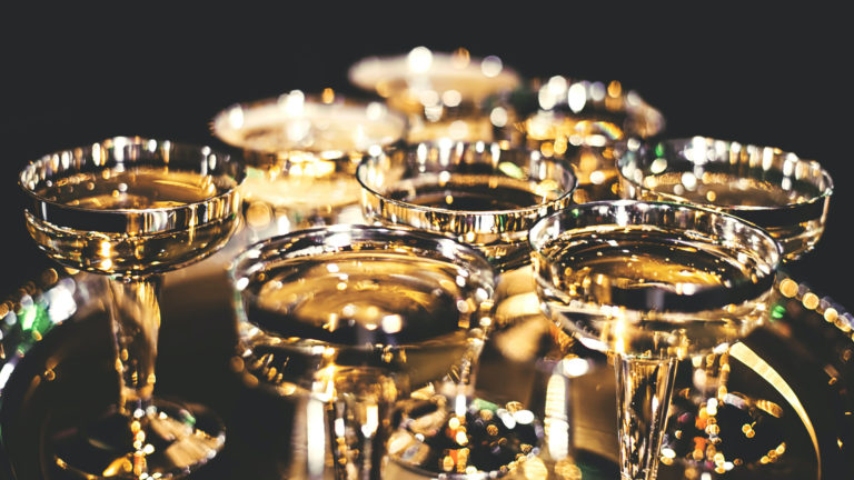 A platter on which rest gold rimmed champagne coupes